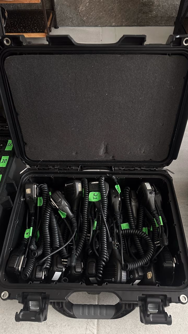 Case de radios de comunicación con cargadores y headsets listos para el crew