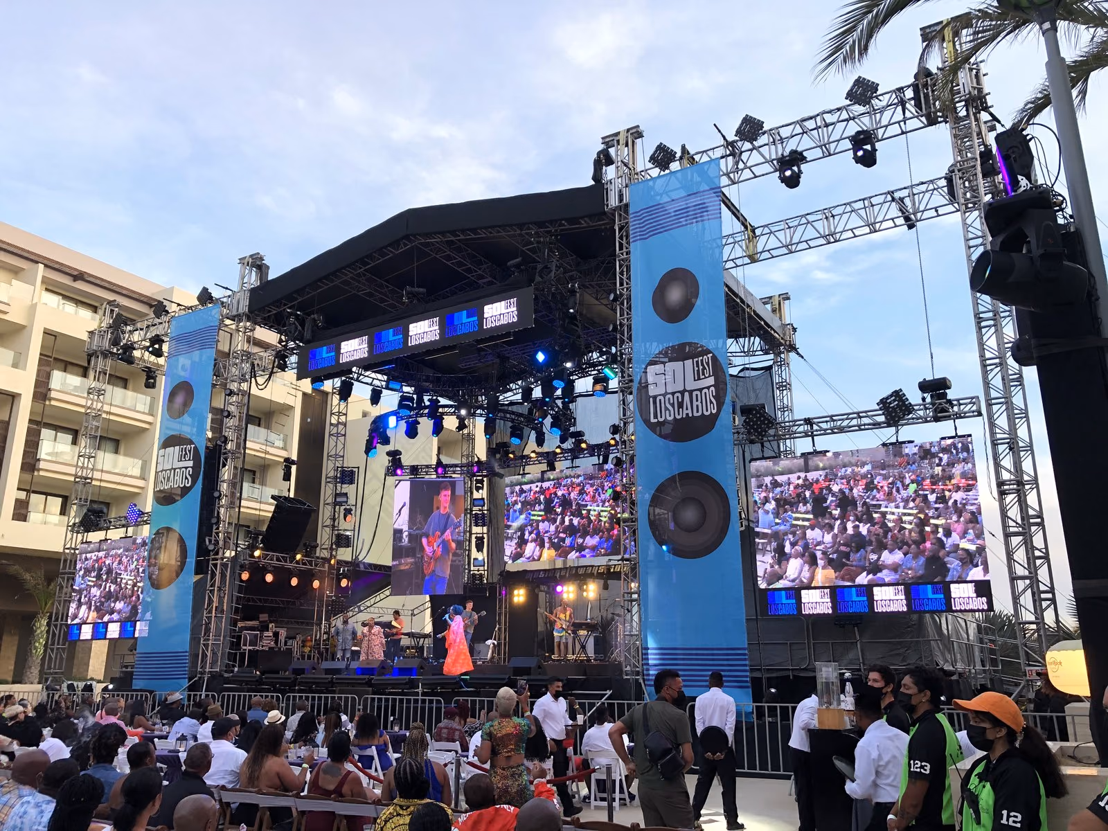 Escenario al aire libre de Sol Fest en Los Cabos con torres de audio y público de día